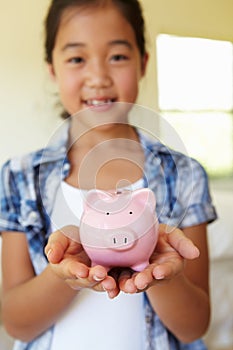 Young girl holding piggybank