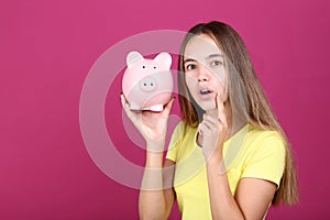 Girl holding pink piggybank