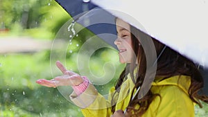 Young girl holding an umbrella and playing in the rain