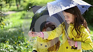 Young girl holding an umbrella and playing in the rain