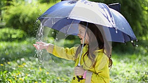 Young girl holding an umbrella and playing in the rain