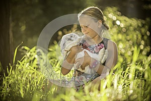 Young girl is holding white rabbit