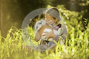 Young girl is holding white rabbit