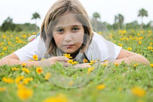 Girl Layng in Field of Yellow Flowers