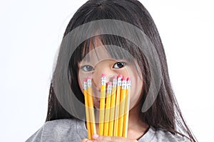 Young girl holding yellow pencils