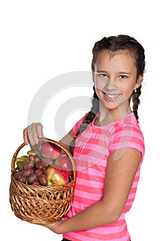 Young girl holds a basket with vegetables