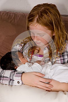 Young girl holds her 3 weeks old baby niece