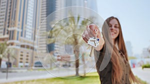 The young girl holds the keys. The concept of buying an apartment or car in Dubai.