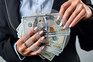 young girl holds a large sum of dollars in her hands and counts money in a black purse.