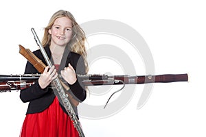 Young girl holds woodwind instruments in studio