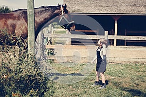 Young girl with a horse in the field