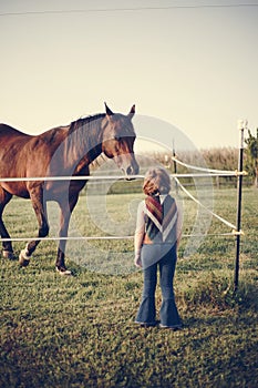 Young girl with a horse in the field