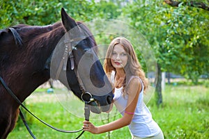 Young girl with a horse in the garden.