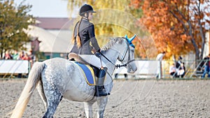 Young girl on horse on show jumping competition