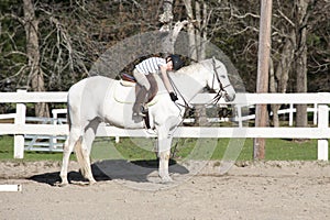 Young girl hugging horse at riding lesson.