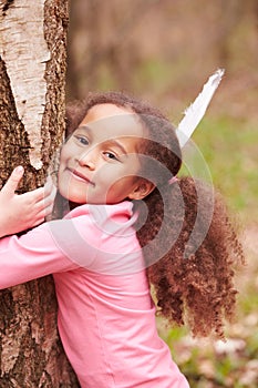 Young Girl Hugging Tree In Forest