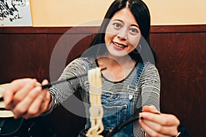 Young girl hungrily showing the udon noodle