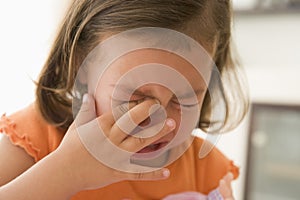 Young girl indoors crying