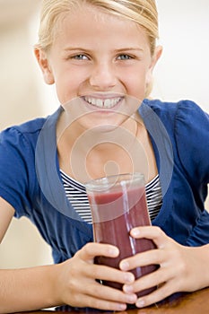 Young girl indoors drinking juice