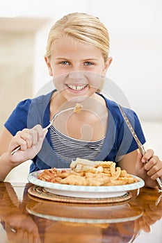 Young girl indoors eating fish and chips