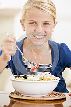 Young girl indoors eating seafood