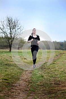 A young girl jogging in a park