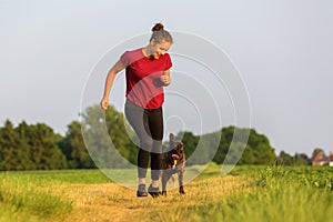 Young girl jogs with a boxer dog