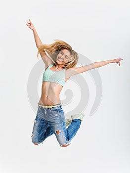 A young girl jumping against white studio background