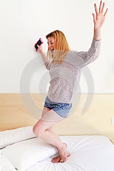 Young girl jumping on the bed