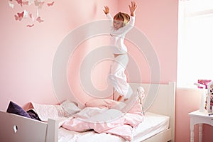 Young Girl Jumping On Her Bed