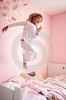 Young Girl Jumping On Her Bed