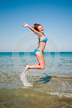 Young girl jumping out of water