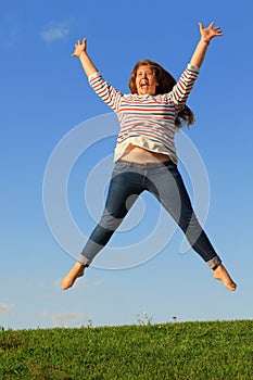 Young girl jumps and screams at grass