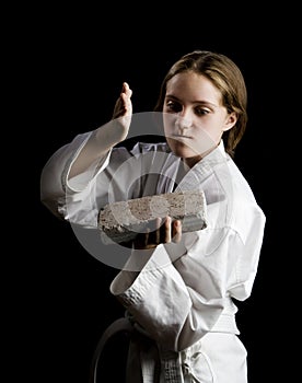 Young girl karate chopping a brick