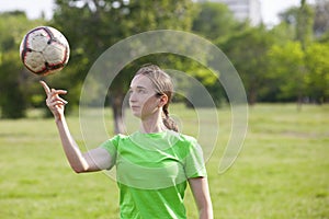 Young girl kicking soccer ball on field