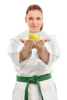 Young girl in kimono offering an apple