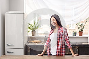 Young girl at kitchen healthy lifestyle leaning on table looking camera relaxed