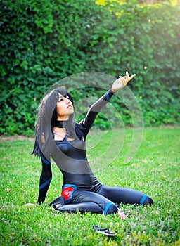 Young girl kneels and stretches out his hand to the sky.