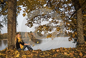 Young girl on lake coast. Sunny Autumn Day