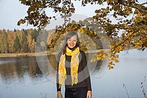 Young girl on lake coast. Sunny Autumn Day