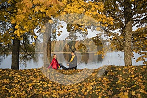 Young girl on lake coast. Sunny Autumn Day