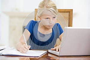 Young girl with laptop doing homework