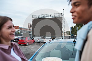 Young girl laughing with man near car during film session