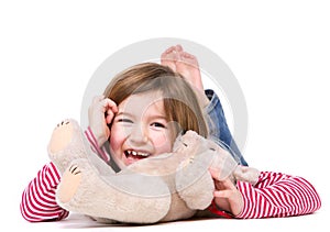 Young girl laughing with teddy bear