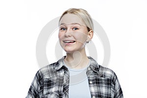 The young girl laughs. A cute blonde with freckles on her face wearing a black and white checkered shirt and a blue top.