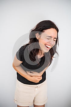 Young girl laughs and holds her tummy