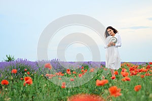 Young girl is in the lavender field with red poppy flowers, beautiful summer landscape