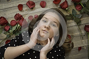 Young Girl with rose petals laying on the floor