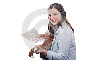 Young girl learning to play guitar, on white