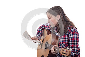 Young girl learns to play guitar on white